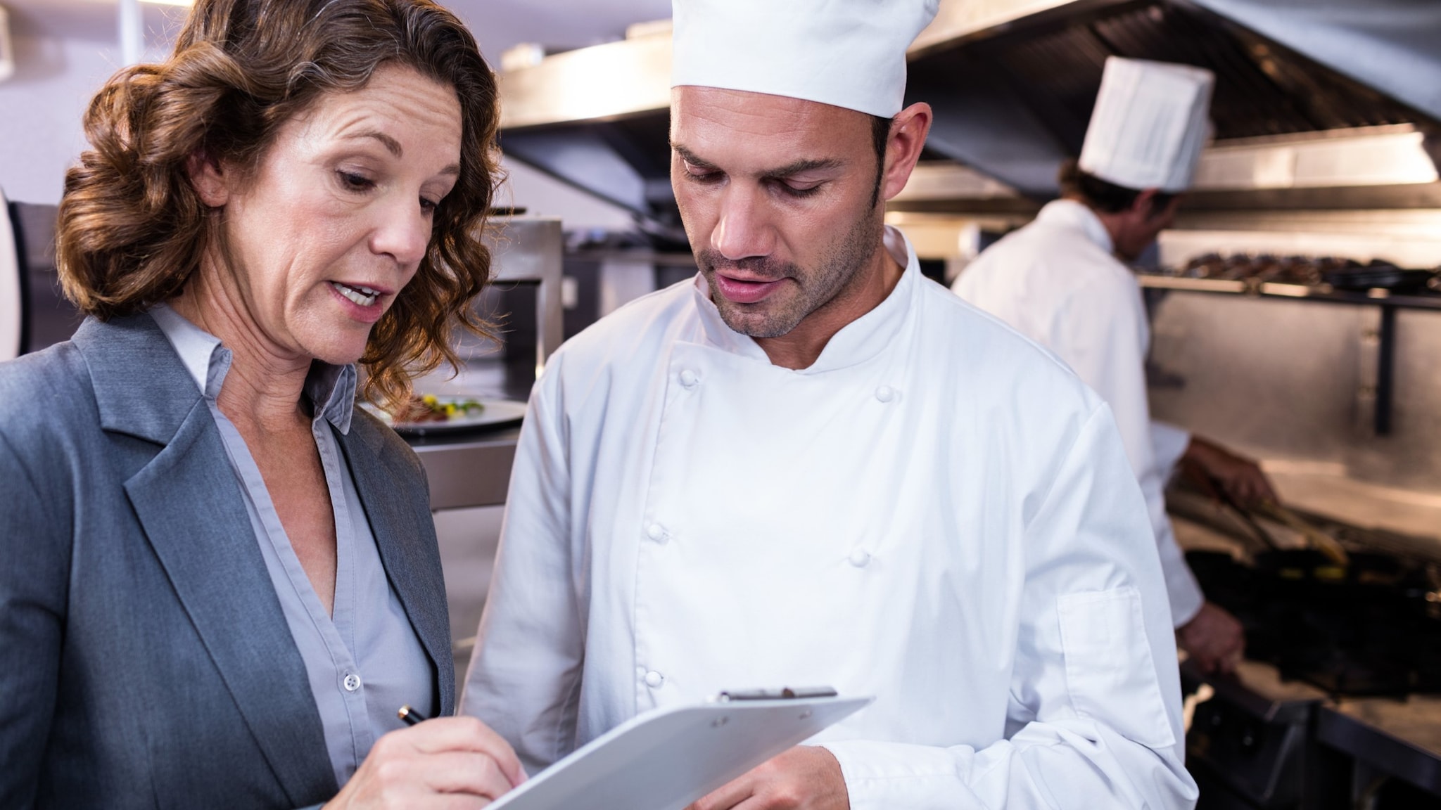 Food safety inspector talks to a chef.