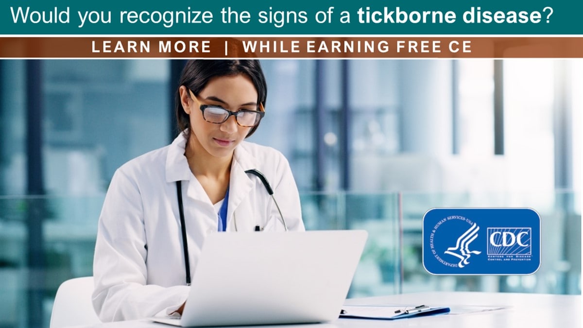 A healthcare professional at a desk works on a notebook computer.