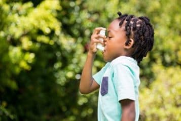 A child uses an asthma inhaler.