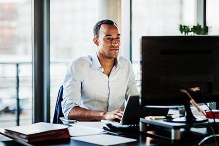 A man working on his computer at his desk.