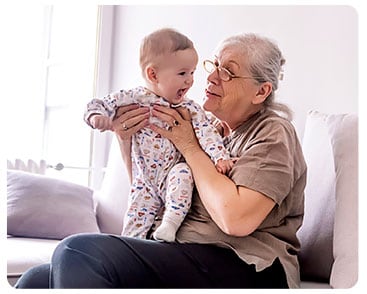 Grandma playing with grandchild on lap.