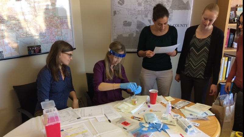 four women running a urine test