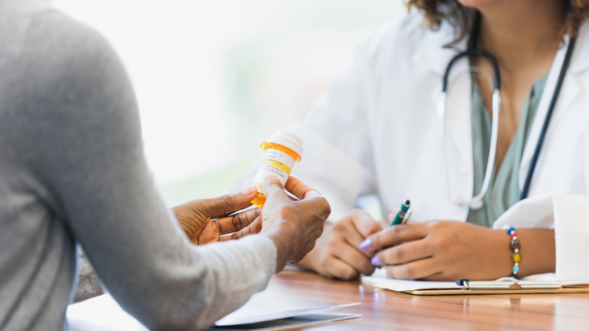 Doctor giving a prescription to a patient.