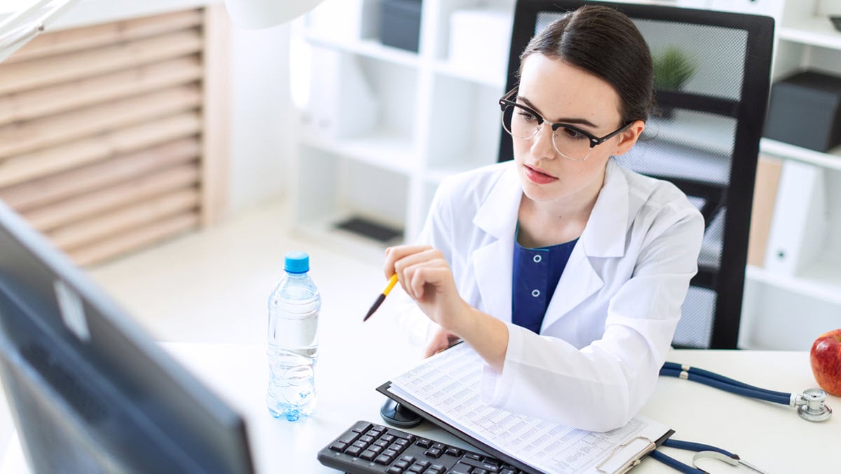 Health care provider working on a computer.