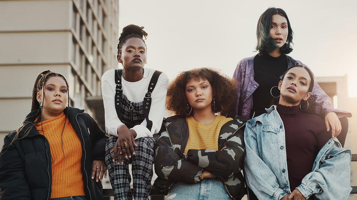 A group of five African American women sitting outside.