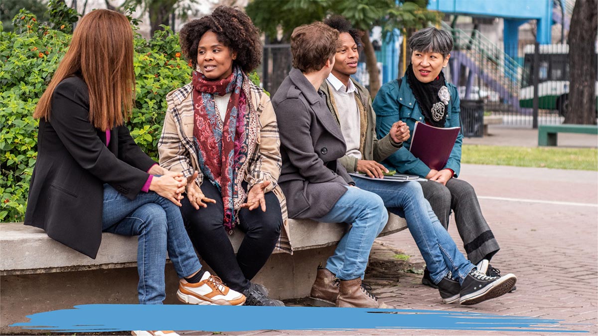 Group of people sitting outside on a bench